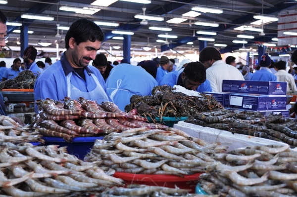 Man at fish market serving prawns