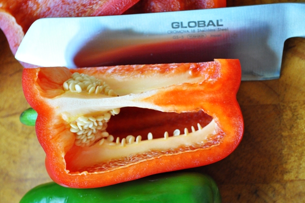 A knife cutting into a pepper