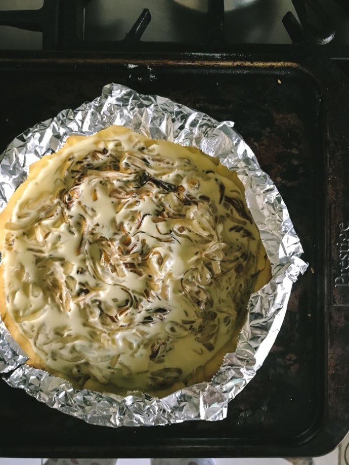 Protecting the edges of the tart with silver foil before cooking in the oven