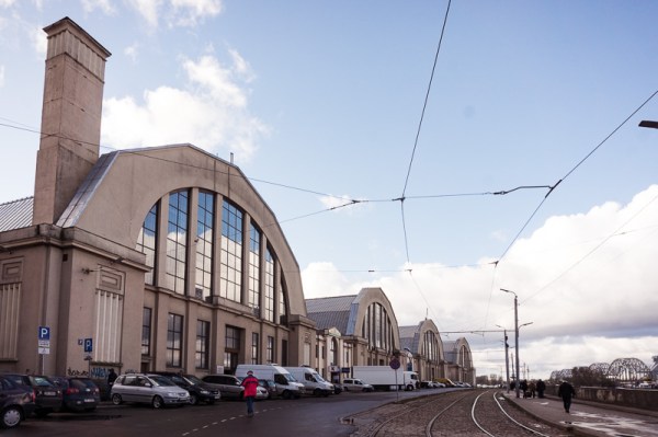 Domed market with man in a red coat walking in front of it