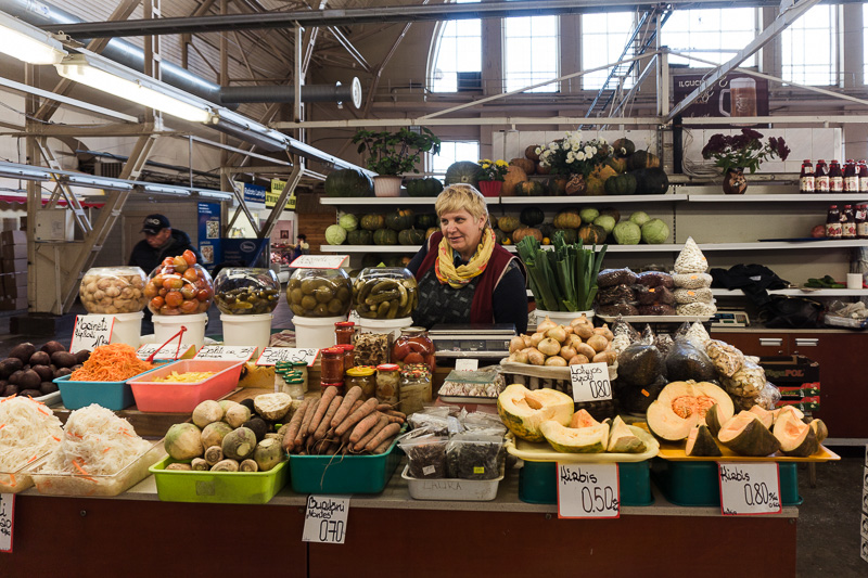 A lady behind a fruit and veg stall