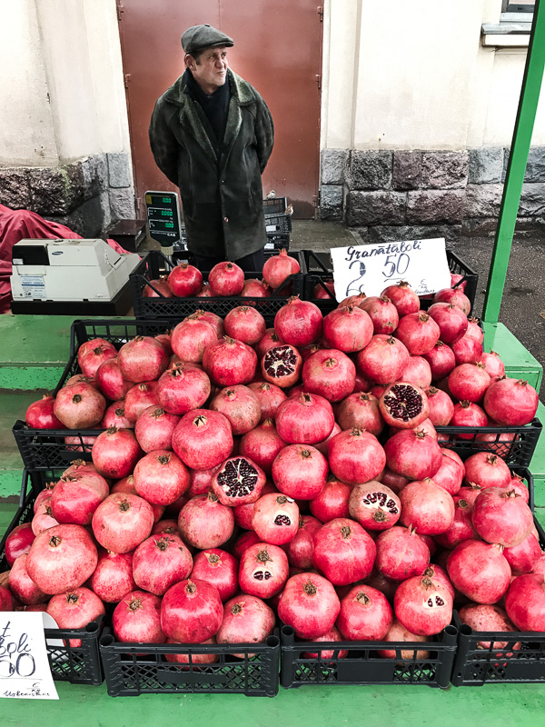 Man behind stall of pomegranates