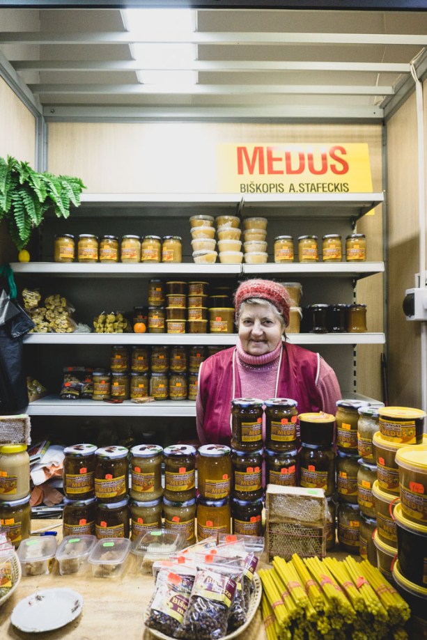 Lady in front of jars of honey at market in Riga