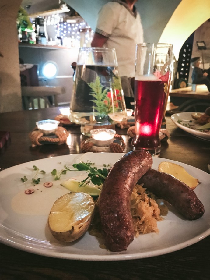 sausages and potatoes and goldfish in bowl on table, riga restaurant