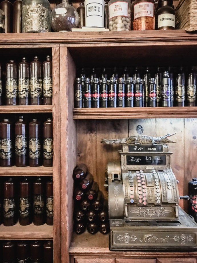 Wooden shelves lined with bottles of balsam in Riga