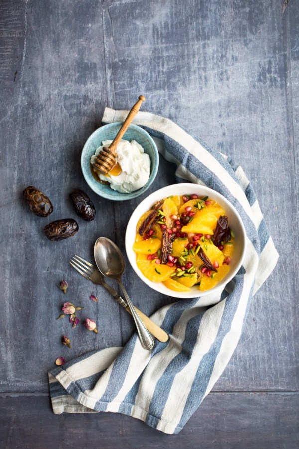 Date and orange fruit salad, yoghurt in a bowl, dates and some cutlery