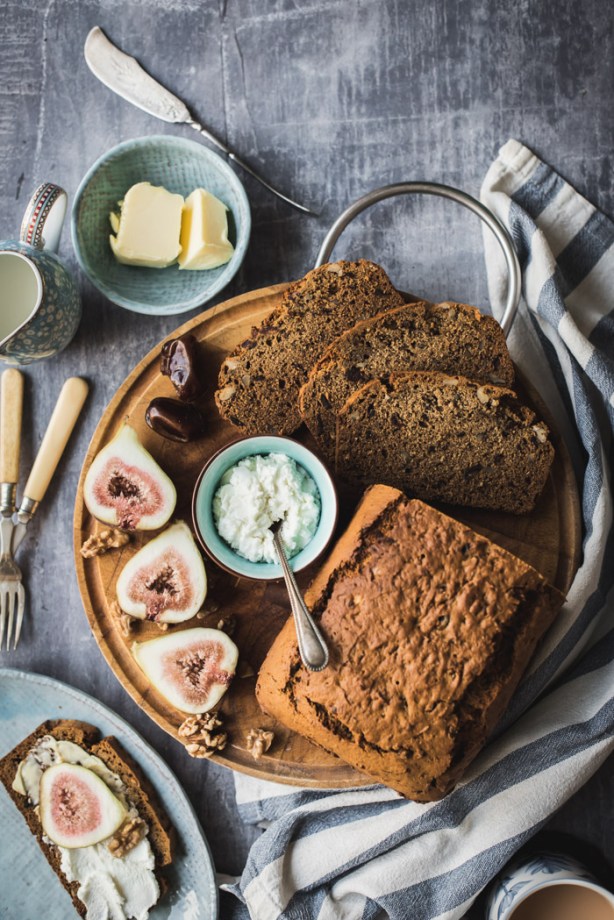 wooden board with date and walnut cake in slices
