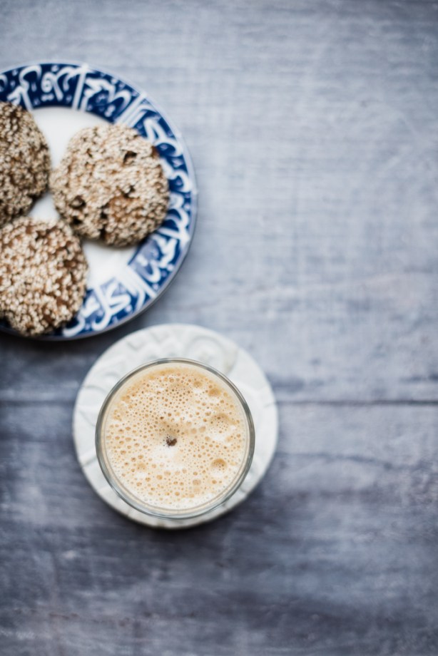 a glass of date lassi and a plate of biscuits