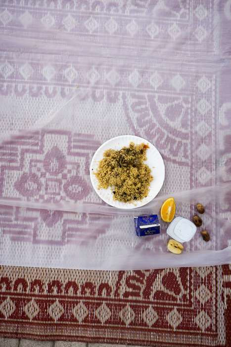 a plate of biryani, some dates, water and laban