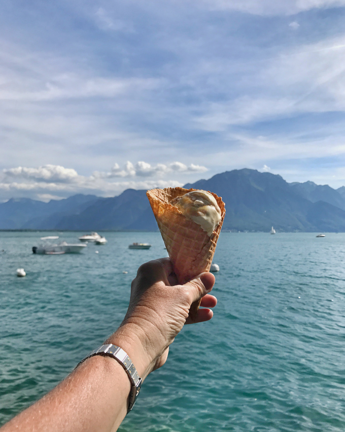 Hand with ice cream in front of lake