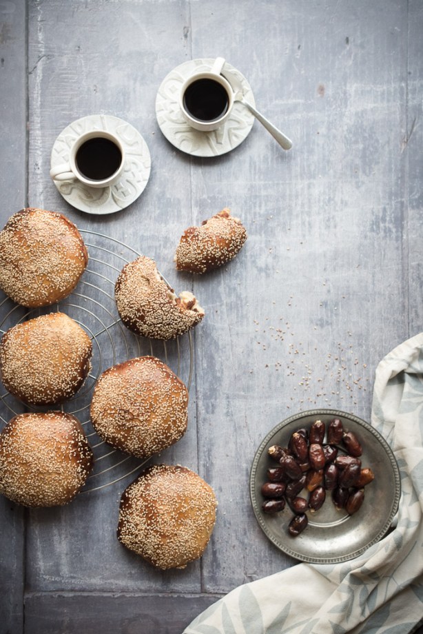 A variety of date breads, 2 cups of coffee and a plate of dates