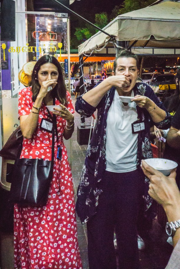 two women eating pani puri on a food tour in Dubai