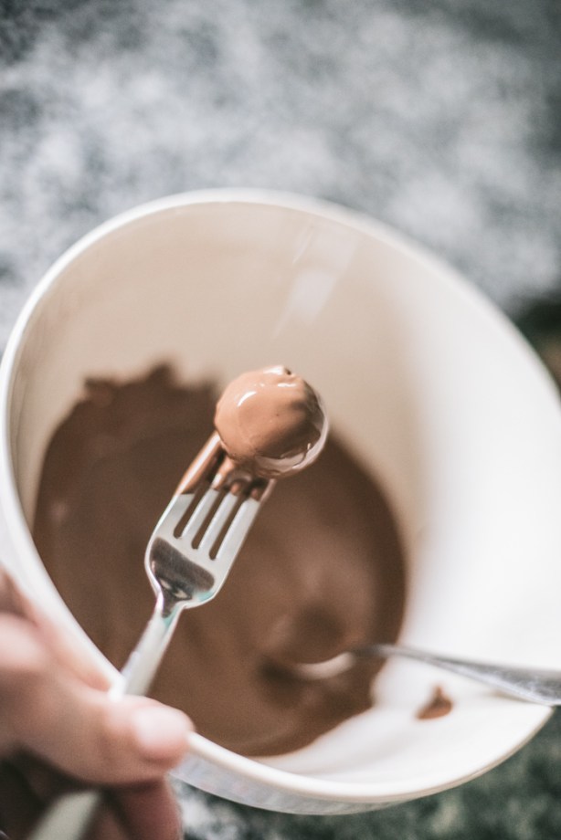 Dipping Tim Tam Truffles into melted chocolate