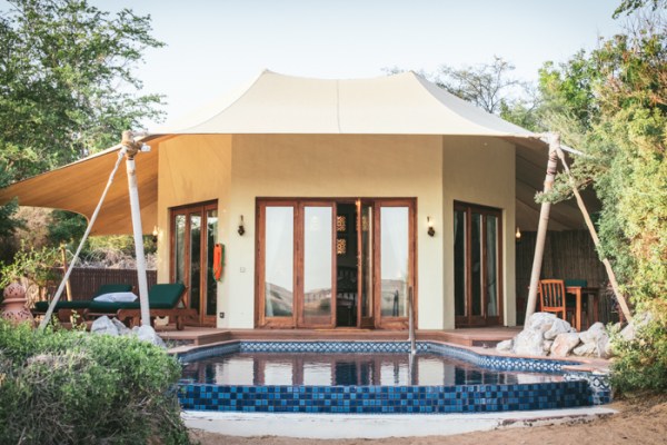 tent like building in front of an infinity pool 