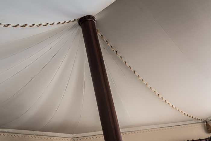 tented roof with stitched seams supported by a wooden pole