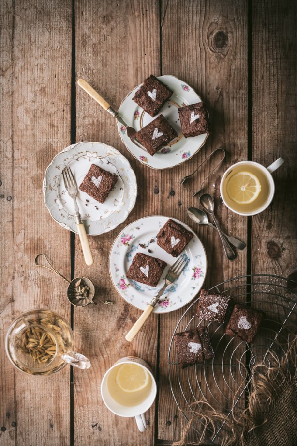Three plates of fudgy chocolate brownies and two cups of herbal tea