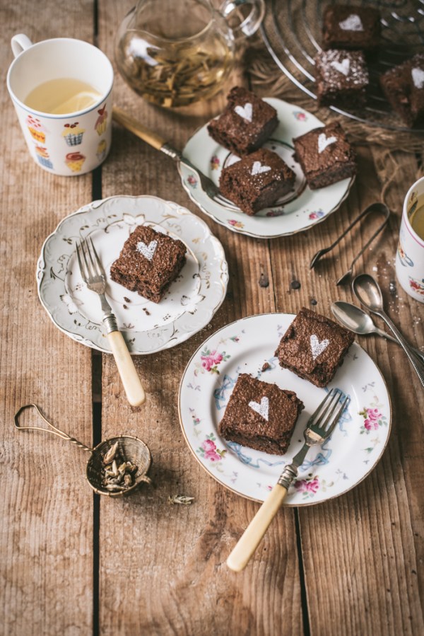 Three plates of fudgy chocolate brownies and two cups of herbal tea
