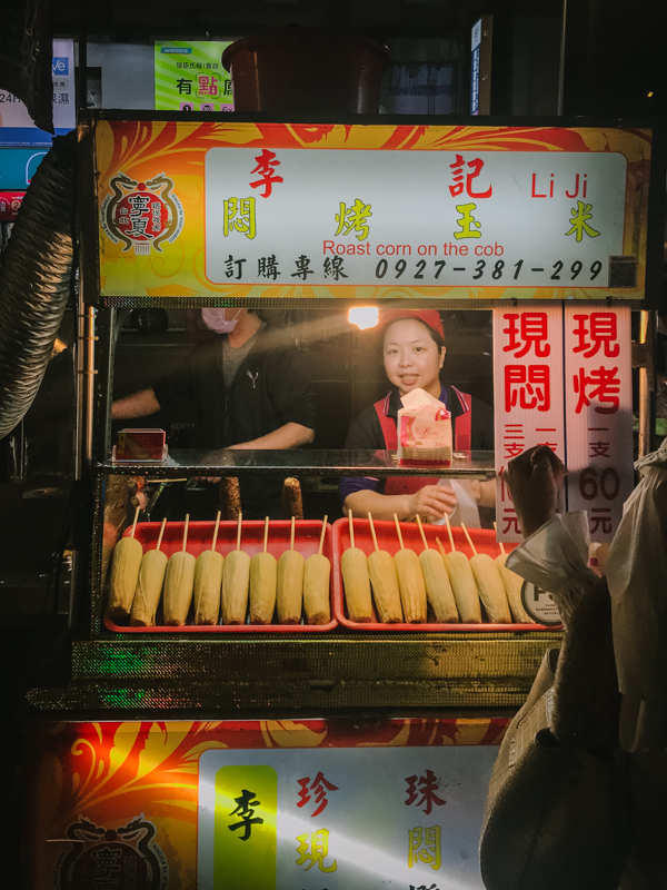 corn cobs on sticks at a stall