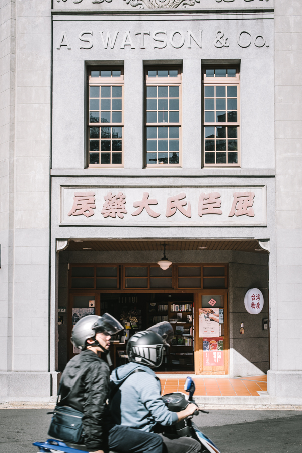 two people on a motorbike in front of AS Watson