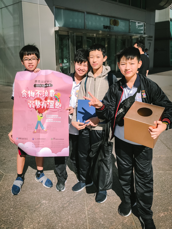 four boys carrying a box