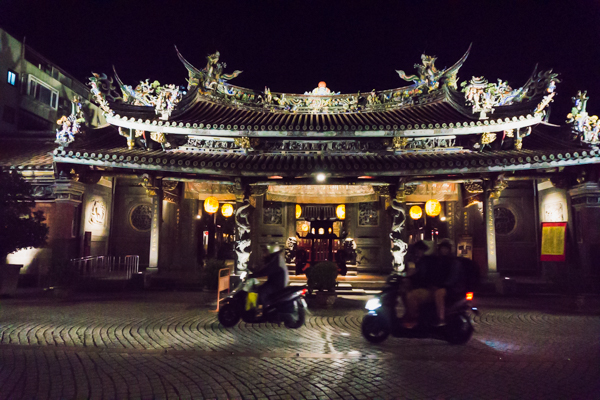 Motorbikes driving past the Baoan temple