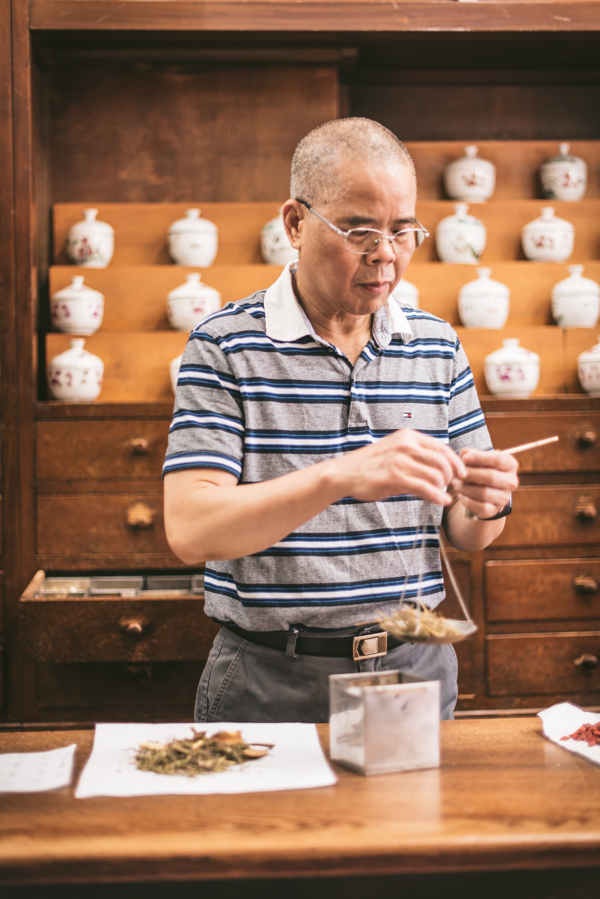 man weighing out chinese medicine