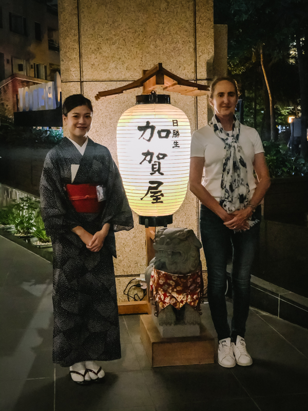 two women standing by Chinese lamp
