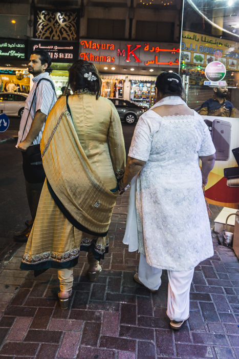ladies in saris holding hands