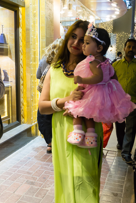 Lady holding child in pretty clothes