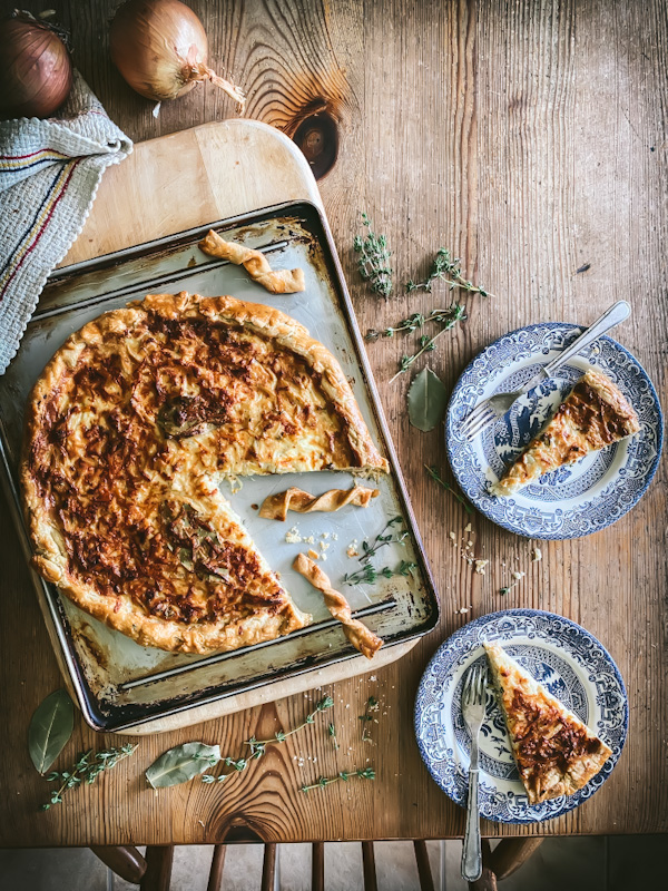 onion and thyme tart with slices on plates